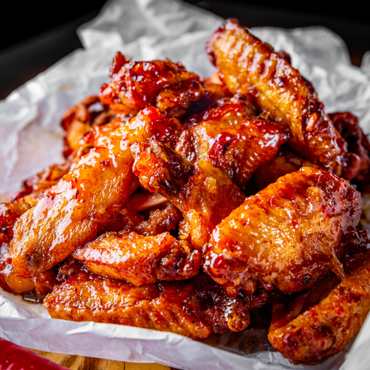 fried chicken wings with sweet chili sauce on white paper