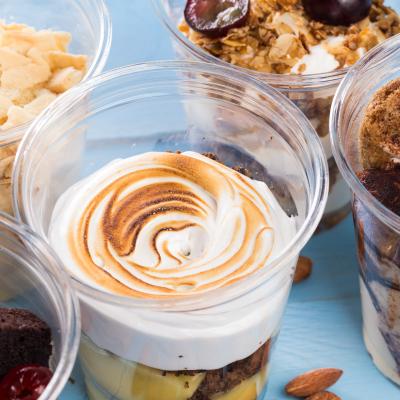 Close up of several desserts in cups